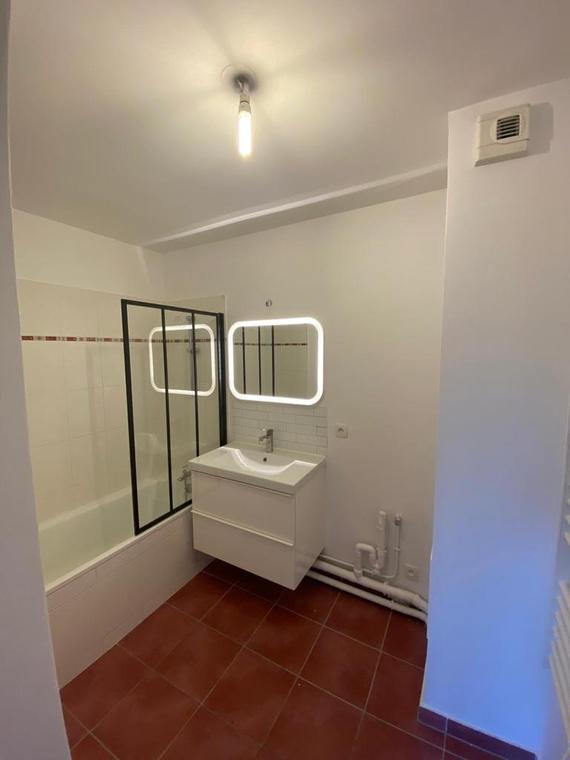 Salle de bains avec paroi de douche noire et meuble vasque