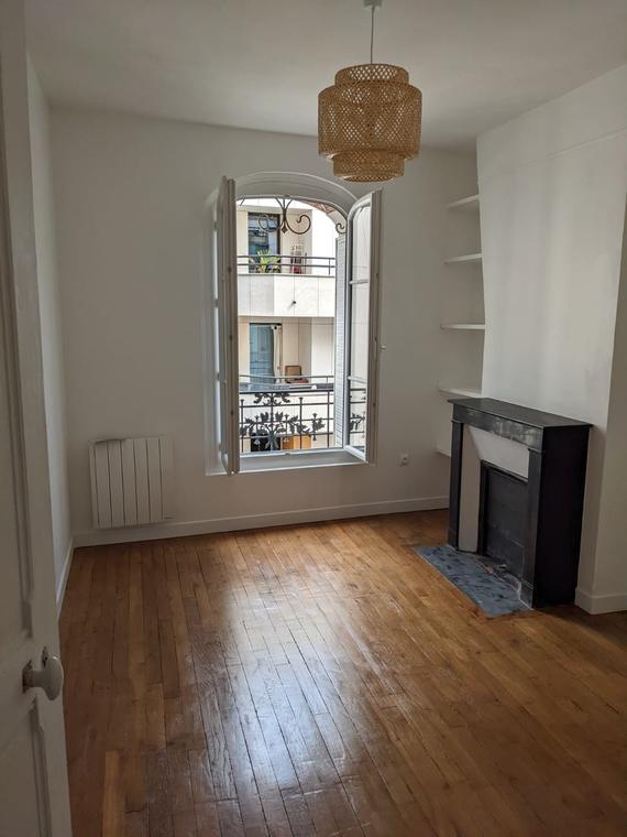 Pièce avec cheminée, parquet ancien et murs repeints