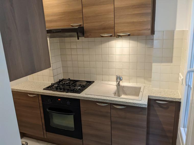 Cuisine aménagée avec meubles bois et plaques de cuisson