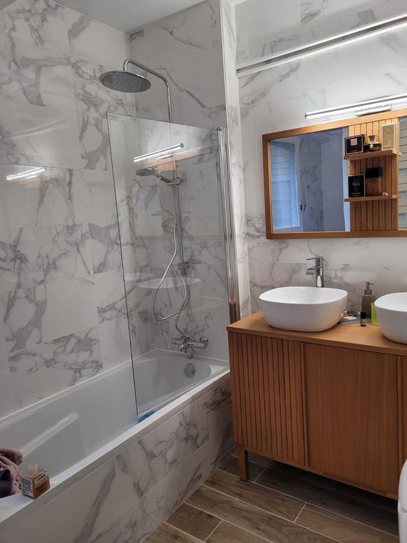 Salle de bains en marbre avec meuble vasque en bois