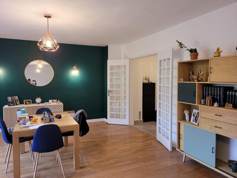 Salon rénové avec mur peint en vert et parquet